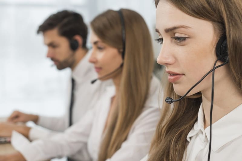 Agentes de call center con diademas atendiendo llamadas