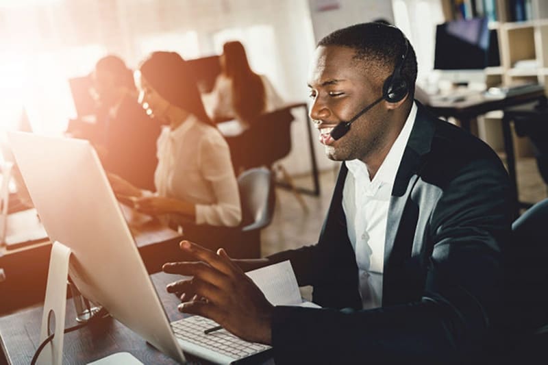 Operador de call center con diadema respondiendo preguntas